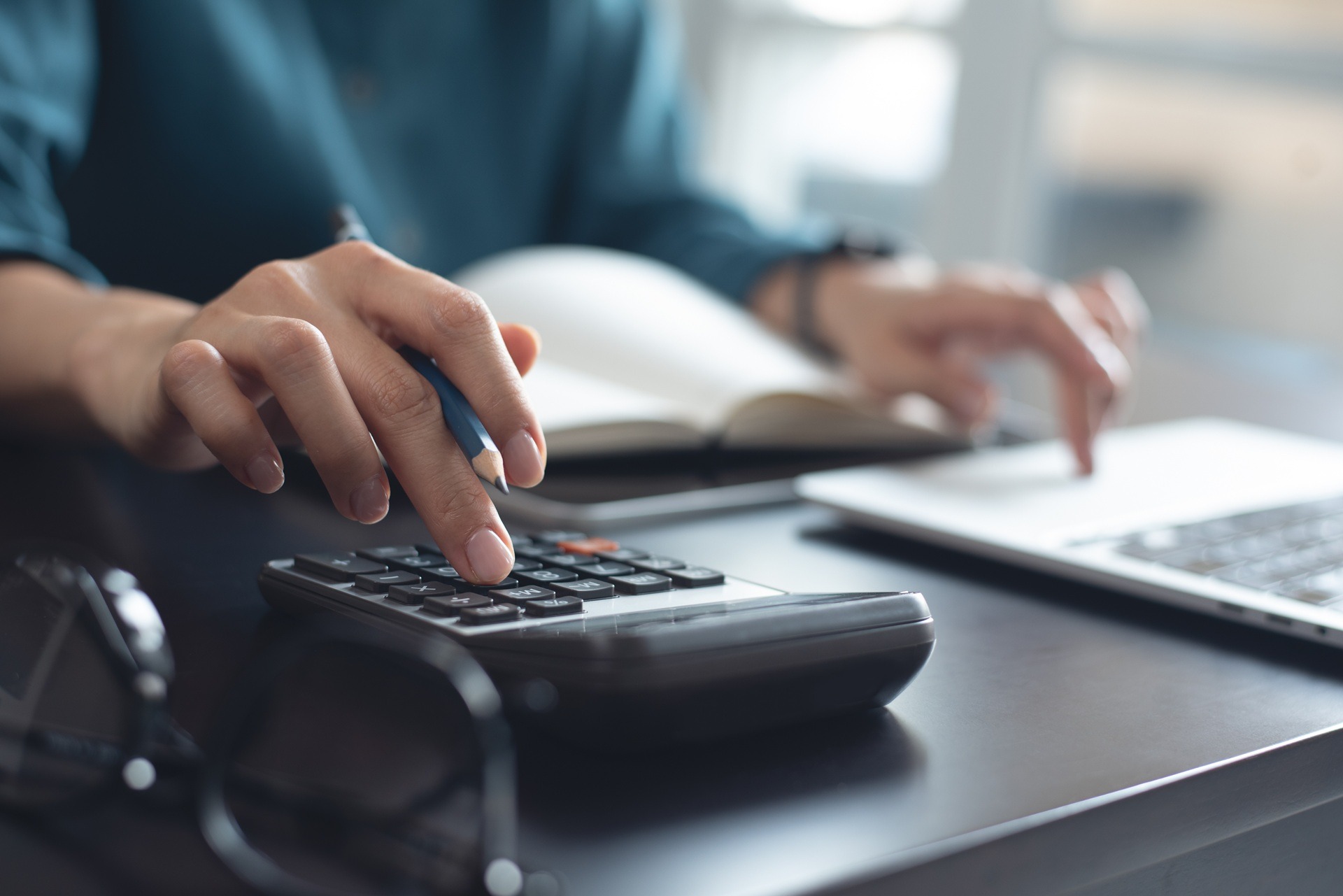 Person berechnet Kosten mit Taschenrechner | Predictive Maintenance